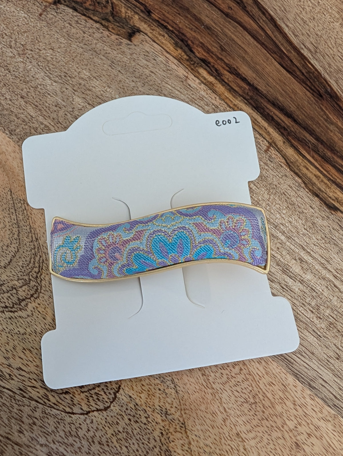 E002 - Purple iridescent Song Brocade wave barrette on packaging card